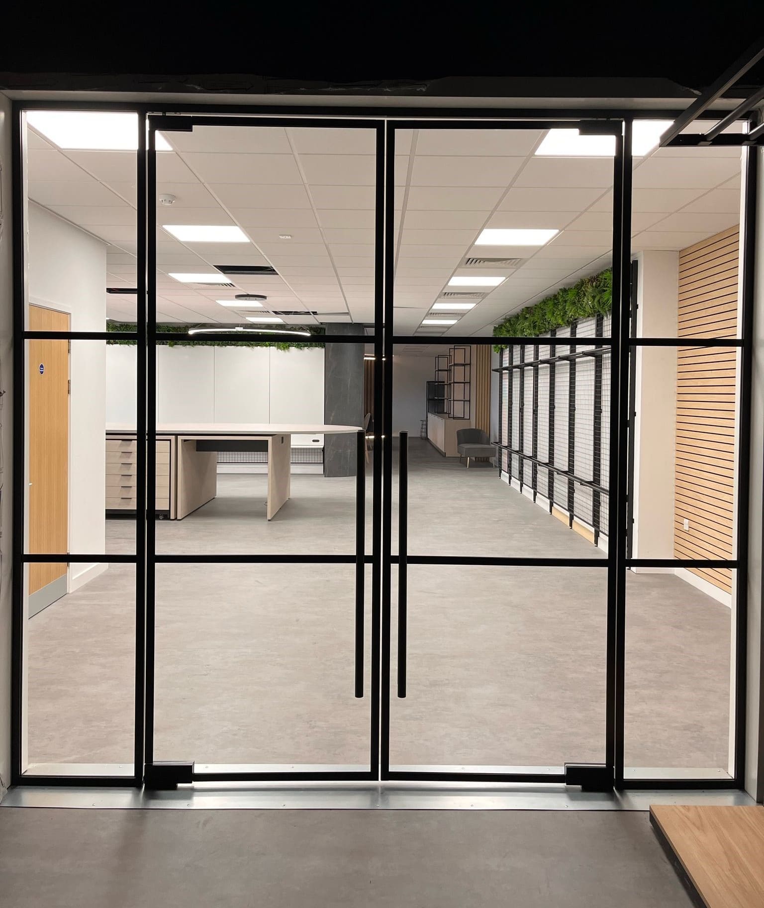 Commercial glass partition with frameless double doors