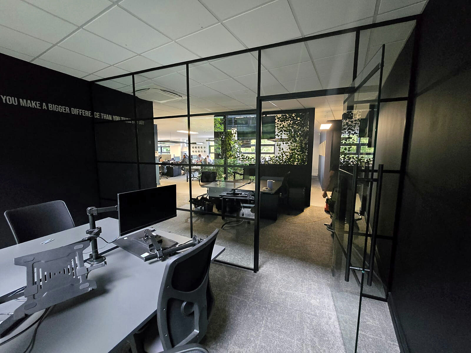 Industrial-style glass office partition dividing a modern office while retaining light and visibility
