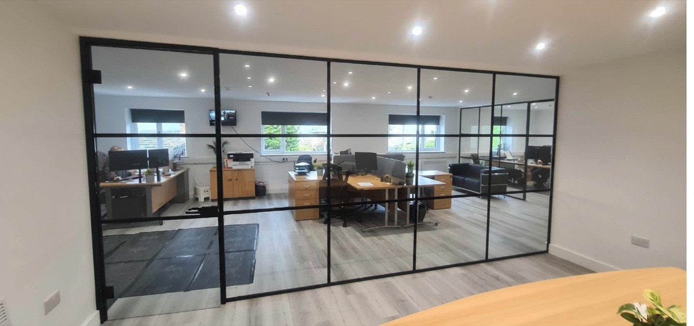 Black framed glass partition and door installed in commercial premises